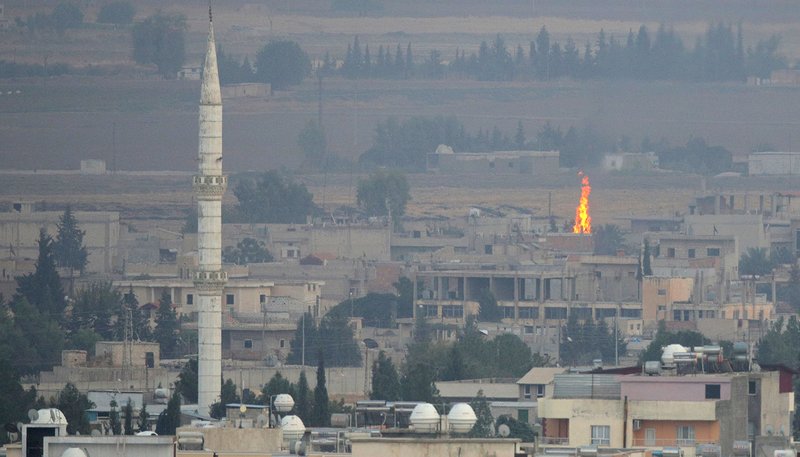 A fire is seen Oct. 16, 2019, in the Syrian town of Ras al Ain from the Turkish border city of Ceylanpinar. In an Oct. 17 plea, Archbishop Timothy P. Broglio of the U.S. Archdiocese of the Military Services, chairman of the U.S. bishops' Committee on International Justice and Peace, urged countries choose "dialogue over confrontation" to resolve their differences. (CNS photo/Stoyan Nenov, Reuters)
