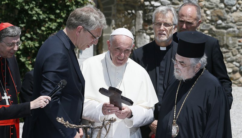 Pope Francis exchanges gifts with the Rev. Olav Fykse Tveit, general secretary of the World Council of Churches, and other Christian leaders at the WCC's Ecumenical Institute at Bossey, near Geneva, in 2018. Responding in October to a WCC document on the nature and mission of the church, the Vatican said that while Catholics cannot share the Eucharist with other Christians, they can and should pray and work together. (CNS photo/Paul Haring)