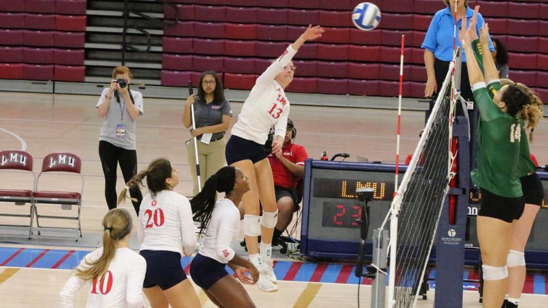 LMU’s Rose Booth (13) goes high for a kill in the Lions’ sweep of USF on Sept. 28. LMU began the WCC season with two straight-set wins. (LMU Athletics)