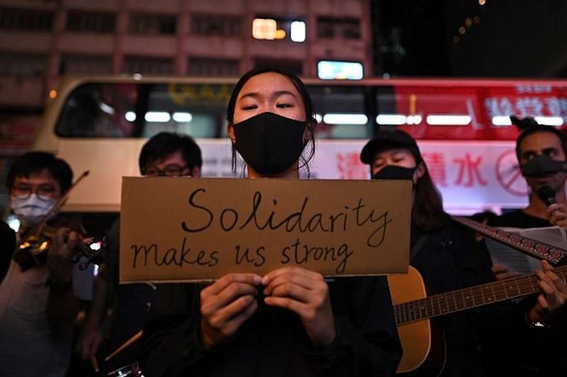 People attend a flash mob singing event outside Chungking Mansions in Tsim Sha Tsui district in Hong Kong on October 23, 2019. (PHILIP FONG/AFP via Getty Images via CNA)