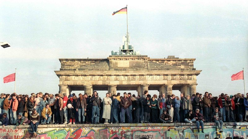 People stand atop the Berlin Wall in front of the Brandenburg Gate in this Nov. 10, 1989, file photo. Catholic bishops from the European Union marked 30 years since the breaching of the Berlin Wall with tributes to those who worked for peaceful change, as well as warnings against resurgent "ideologies behind the building of walls." (CNS photo/David Brauchli, Reuters)