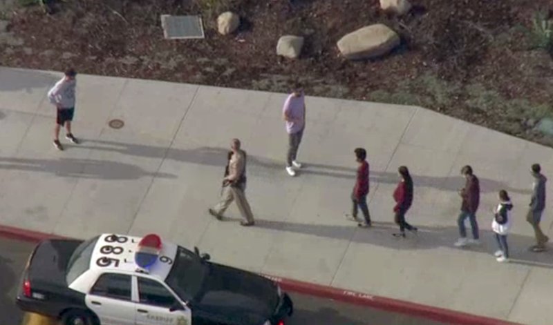 A law enforcement officer leads students at the scene of a shooting Nov. 14, 2019, at Saugus High School in Santa Clarita, Calif., in this screenshot taken from video footage courtesy of NBCLA. (CNS photo/NBCLA via Reuters)