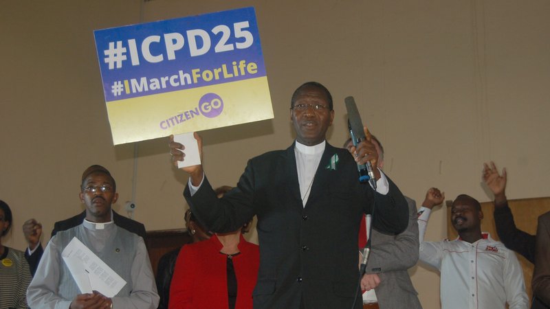 Retired Bishop Alfred Rotich, vice chairman of the Family Life Commission of the Kenya Catholic Bishops' Conference, speaks while holding a placard during the closing of a meeting of the parallel population summit in Nairobi Nov. 14, 2019. (CNS photo/Fredrick Nzwili)