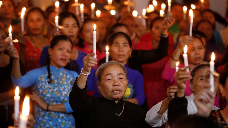 Women hold candles during a service at a church in My Khanh, Vietnam, Oct. 26, 2019, for 39 Vietnamese migrants found dead in the back of a truck at the Port of Tilbury in Essex, England. In a message to young Catholics in Vietnam, Pope Francis offered prayers for the migrants, who died while being smuggled into Great Britain in late October. (CNS photo/Kham, Reuters)