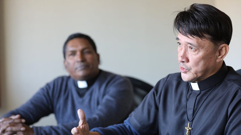 Franciscan Father Neville Fernando of Negombo, Sri Lanka, listens as Oblate Oblate Father Romeo Saniel, apostolic administrator of the Vicariate of Jolo, Philippines, speaks during a Nov. 21, 2019, interview in Washington. Father Fernando has participated in several rounds of peace negotiations between the Philippine government and Muslim factions. (CNS photo/Bob Roller)