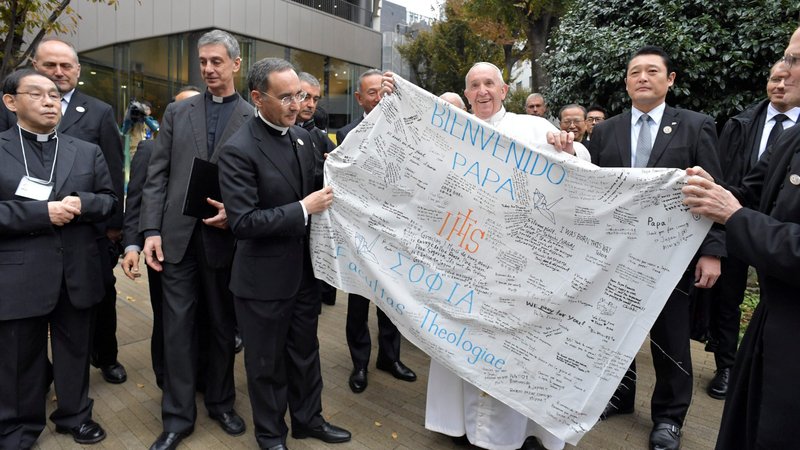 Pope Francis receives a welcome banner from the theology faculty at Jesuit-run Sophia University in Tokyo Nov. 26, 2019. (CNS photo/Vatican Media via Reuters)