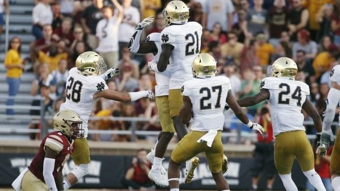 Notre Dame's Shaun Crawford, center behind, celebrates with teammate Jalen Elliott (21) after his interception off Boston College's Kobay White, left, during the second half of an NCAA college football game in Boston, Saturday, Sept. 16, 2017. Notre Dame won 49-20. (Michael Dwyer/AP via Crux)