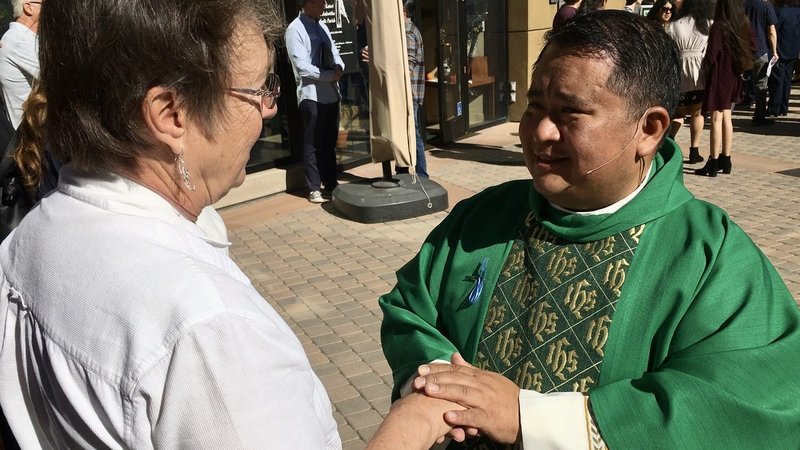 Fr. Albert Avenido, pastor at Saint Kateri Tekakwitha Catholic Church in Santa Clarita, comforts a grieving woman after Mass Nov. 17. (Tom Hoffarth/Angelus News)