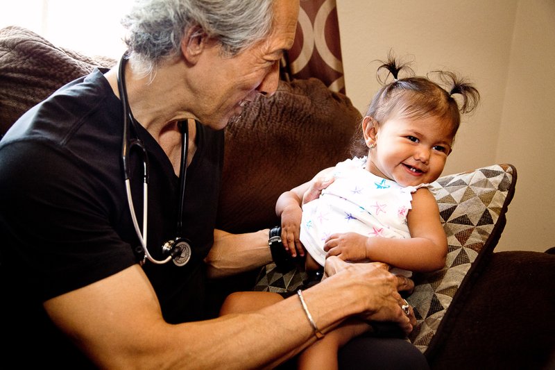 TrinityKids Care medical director Dr. Glen Komatsu with a child patient. (Taso Papadakis / Providence TrinityCare Hospice Foundation)