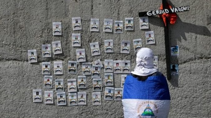 A demonstrator near the Metropolitan Cathedral in Managua, Nicaragua, looks at pictures Nov. 2, 2019, of protesters who died during the protests against President Daniel Ortega's government last year. (Oswaldo Rivas/Reuters/CNS via Crux)
