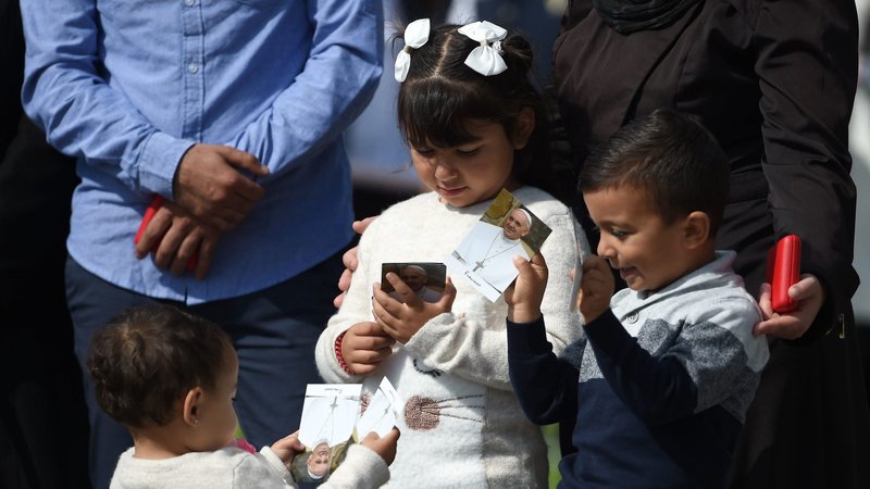 Young Syrian refugees hold photos of Pope Francis during his visit to meet Irish President Michael Higgins in Dublin Aug. 25, 2018. Ireland's Catholic bishops have criticized the use of intolerant language when it comes to discussions around migration and refugees. (CNS photo/Joe Giddens, Reuters)