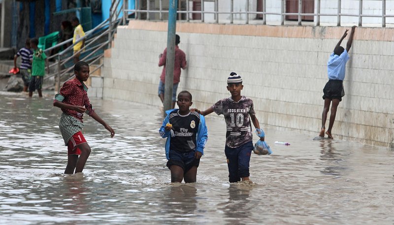 Young Somalis walk through floodwaters after heavy rains in Mogadishu Nov. 26, 2019. Caritas, the relief arm of the Catholic Church, has delivered food aid to Muslims in Somalia, who are currently facing floods and living in a fragile peace environment due a prolonged Islamist insurgency. (CNS photo/Feisal Omar, Reuters)