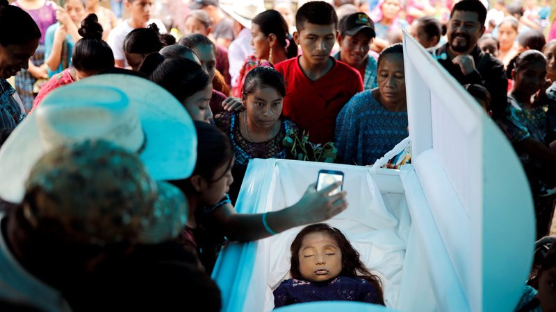 Friends and family gather around the casket of Jakelin Caal Maquin during her funeral and burial Christmas Day 2018 in San Antonio Secortez, Guatemala. She died Dec. 8, 2018, at a hospital in El Paso, Texas, after she was detained along with her father Dec. 6 at a remote border crossing in New Mexico. (CNS photo/Carlos Barria, Reuters)