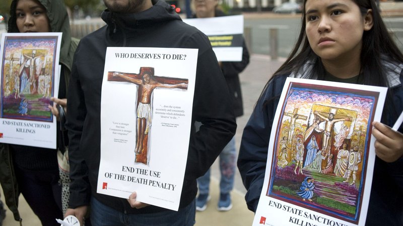 People hold signs during a candlelight prayer vigil Dec. 8, 2019, held to oppose the Trump administration's plan to reinstate the federal death penalty. For now the plan is on hold, as the Supreme Court issued a ruling late Dec. 6 that leaves in place a preliminary injunction stopping the administration's bid to resume federal executions. (CNS photo/David Maung)