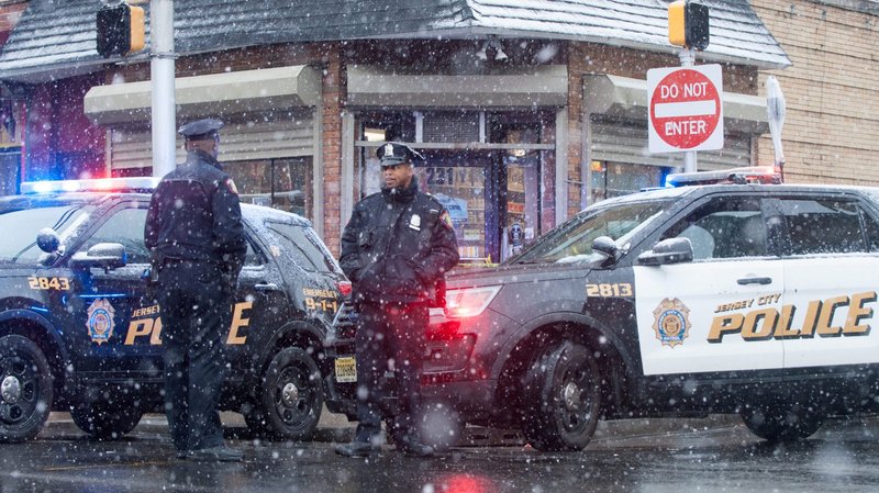 Police stand at the scene Dec. 11, 2019, of a gun battle that took place the day before involving two men around a kosher market in Jersey City, N.J. Six people, including a police officer and three bystanders, were killed in a furious battle that filled the streets of Jersey City with the sound of heavy gunfire for hours, authorities said. (CNS photo/Lloyd Mitchell, Reuters)