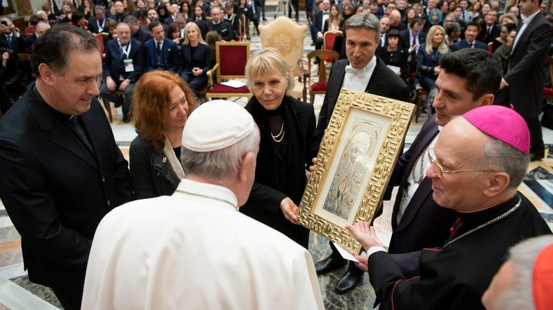 Pope Francis accepts a gift during an audience with a group of international performers at the Vatican Dec. 13, 2019. The performers, including U.S. singer Lionel Richie, were scheduled to perform at the Vatican's Christmas concert the next day. (CNS photo/Vatican Media)