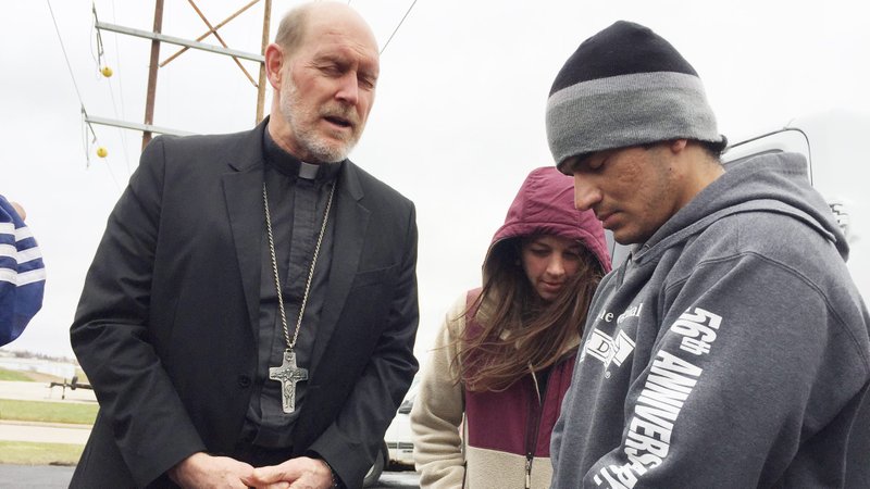 Bishop Thomas R. Zinkula of Davenport, Iowa, prays with a group that includes Alejandro Guzman, a Mexican immigrant, and Emily Sinnwell of the Iowa City Catholic Worker House after Guzman's check-in with Immigration and Customs Enforcement in Cedar Rapids Nov. 27, 2019. The group participated in a Catholic Day of Action to Protect Refugee Families and Children. (CNS photo/Barb Arland-Fye, The Catholic Messenger)
