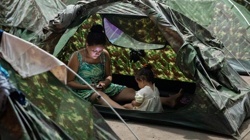 A woman and child are seen May 8, 2019, inside a tent in the bus station housing Venezuelan refugees in Boa Vista, Brazil. About 500 Venezuelans cross the border into Brazil daily basis, according to Catholic officials. (CNS photo/courtesy AVSI)