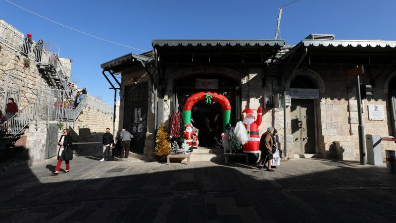 People walk near a Christmas store in Jerusalem's Old City Dec. 18, 2019. (CNS photoAmmar Awad, Reuters)
