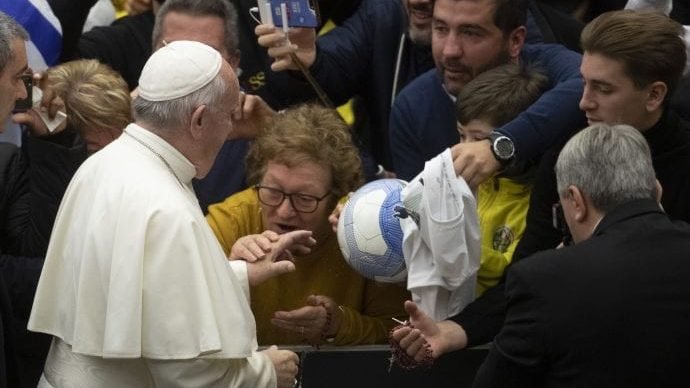 A woman kisses Pope Francis's hand as he arrives in the Paul VI Hall at the Vatican for his weekly general audience, Wednesday, Dec. 11, 2019. (Alessandra Tarantino/AP)