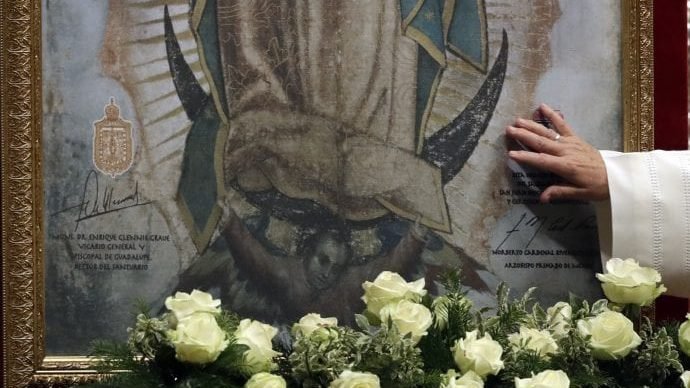 Pope Francis touches a portrait of Our Lady of Guadalupe as he celebrates a Mass in St. Peter's Basilica, at the Vatican, Monday, Dec. 12, 2016. (Gregorio Borgia/AP)
