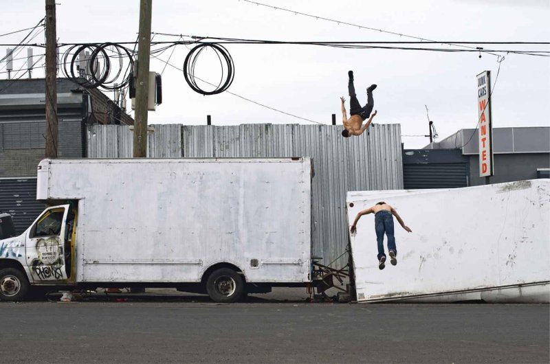A photo from "Dignity" depicting two men who appear to be "flying" in Hunts Point, the Bronx. (Chris Arnade via Amazon)
