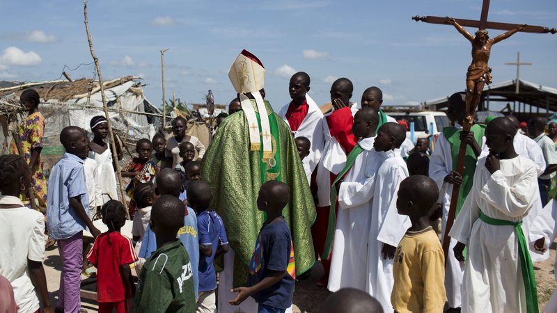 Cardinal Dieudonne Nzapalainga of Bangui, Central African Republic, greets youths after celebrating Mass for internally displaced people in Bangui in this 2015 file photo. Catholic bishops in the Central African Republic have distanced themselves from a group that is promising to defend the church and avenge the deaths of priests. (CNS photo/Siegfried Modola, Reuters)