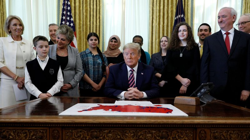 U.S. President Donald Trump attends an event in the Oval Office of the White House to announce his administration's new guidance on prayer in public schools on National Religious Freedom Day Jan. 16, 2020. At left is William McLeod, a student at a public school in Utah. (CNS photo/Tom Brenner, Reuters)