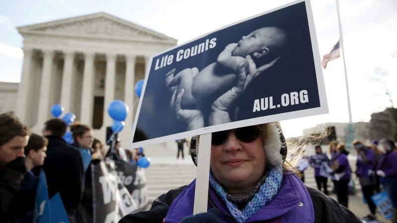 A pro-life supporter holds up a sign in front of the U.S. Supreme Court during a 2016 protest in Washington. In marking the "sorrowful anniversary" Jan. 22 of the Supreme Court's ruling legalizing abortion nationwide, the chairman of the U.S. bishops' pro-life committee said the Catholic Church's pastoral response to all mothers in need "will soon intensify." (CNS photo/Kevin Lamarque, Reuters)