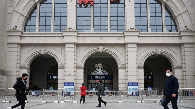 People walk past the closed Hankou Railway Station after the city was locked down following the outbreak of a new coronavirus in Wuhan, China, Jan. 23, 2020. Some churches in China have suspended community activities, including Mass, over fears of the deadly virus. (CNS photo/China Daily via Reuters)
