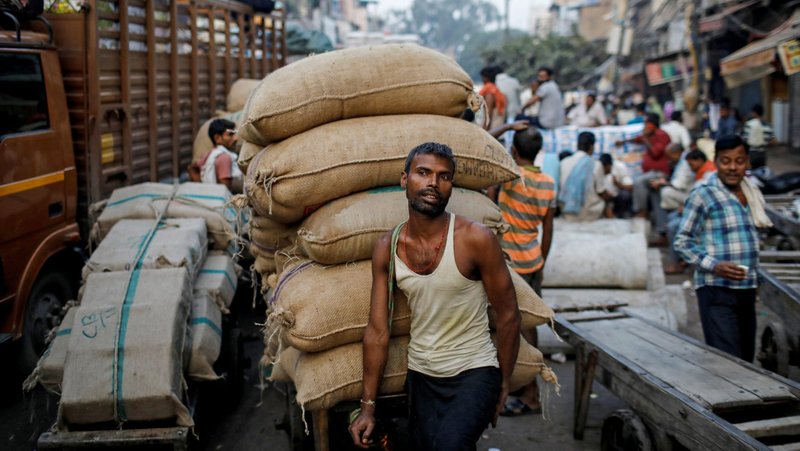 A migrant worker waits to pull his handcart loaded with spices during a traffic jam at a wholesale market in New Delhi Oct. 10, 2019. People who cross international borders to work often face appalling exploitation, yet this is mostly shrugged off by citizens in host countries, said a U.S. bishops' conference participant at a global migration meeting in Quito, Ecuador. (CNS photo/Danish Siddiqui, Reuters)