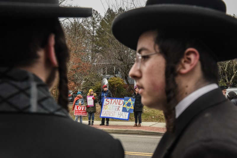 People hold signs of support near the house of Rabbi Chaim Rottenberg on December 29, 2019 in Monsey, New York. Five people were injured in a knife attack during a Hanukkah party and a suspect, identified as Grafton E. Thomas, was later arrested in Harlem. (Stephanie Keith/Getty Images)