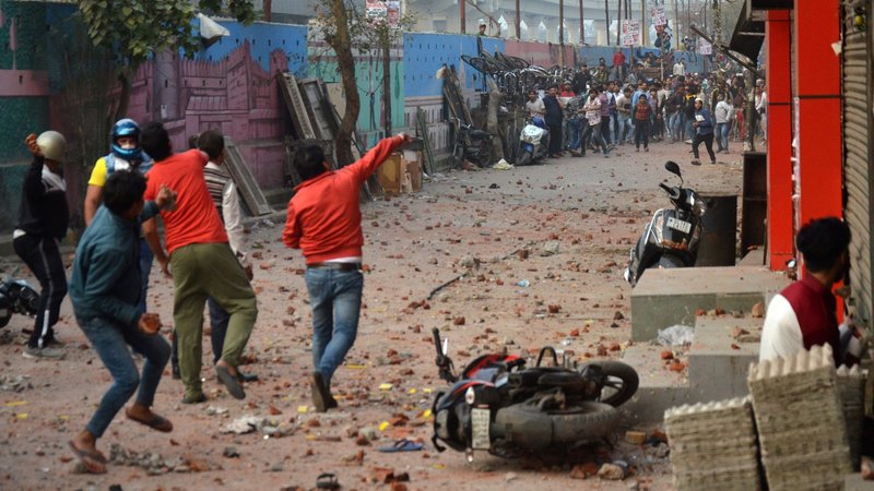 People supporting a new citizenship law and those opposing the law throw stones at each other during a clash in New Delhi Feb. 23, 2020. Christian leaders from different denominations in New Delhi have condemned the communal violence and asked churches to open their doors to victims of the riots. (CNS photo/Akash Jain, Reuters)