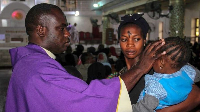 A priest signs the forehead of a child as catholics take part in the Ash Wednesday celebration at the St. Patrick cathedral in Maiduguri on February 26, 2020. (AFP/Getty via CNA)