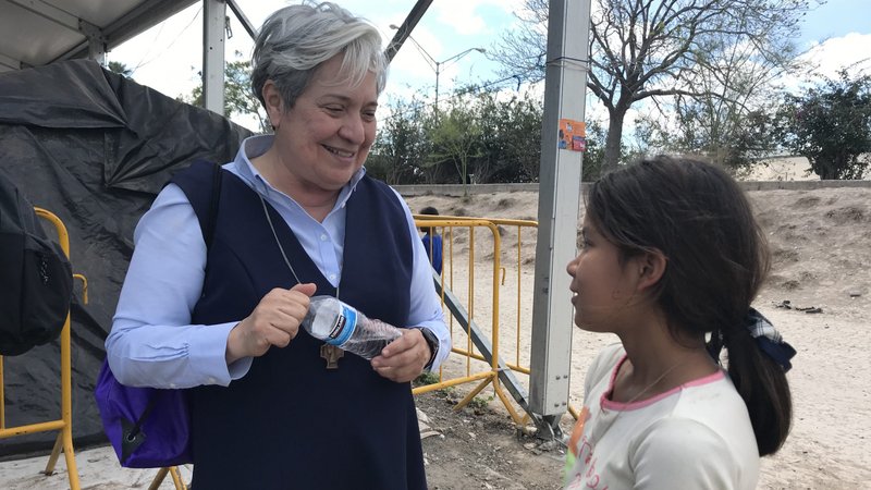 Sister Norma Pimentel, director of Catholic Charities of the Rio Grande Valley in Texas, speaks with a young resident of a tent camp housing some 2,500 asylum seekers in Matamoros, Mexico, Feb. 29, 2020. Sister Norma leads teams providing support for the camp, which is occupied by people forced to stay on the Mexican side of the border while their asylum claims are heard in U.S. courts. (CNS photo/David Agren)