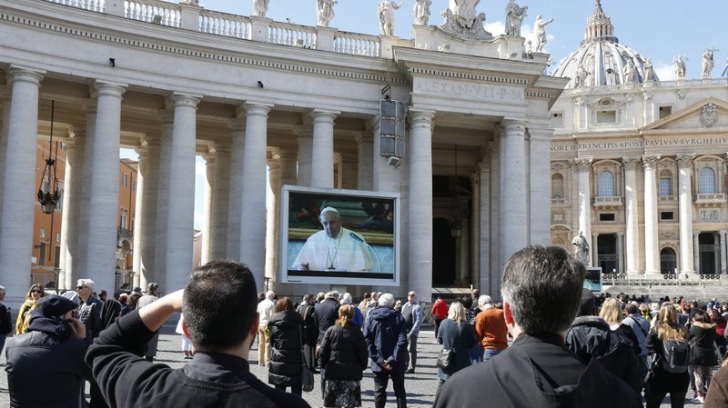 Pope Francis is pictured on a video monitor in St. Peter's Square as he leads the Angelus from his library in the Apostolic Palace at the Vatican March 8, 2020. As a precaution to avoid spread of the coronavirus, the pope's Sunday Angelus was broadcast on television and displayed on monitors in St. Peter's Square. After leading the Angelus through video the pope said he wanted to see the crowd in "real time" and came to the window of his studio to greet people in the square. (CNS photo/Paul Haring)