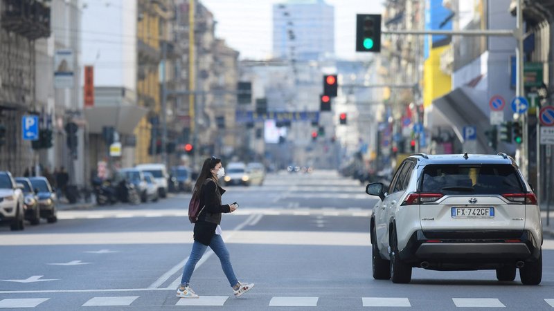 A woman wearing a protective face mask crosses an empty street during the outbreak of coronavirus in Milan March 15, 2020. China's Xi'an Diocese has donated 24,000 disposable medical masks to the Vatican and religious communities and dioceses in Italy such as Milan and Bologna. (CNS photo/Daniele Mascolo, Reuters)