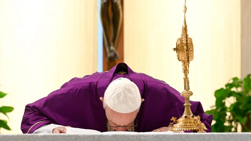 Pope Francis kisses the altar at the end of morning Mass March 20, 2020, in the chapel of his Vatican residence, the Domus Sanctae Marthae. (CNS photo/Vatican Media)