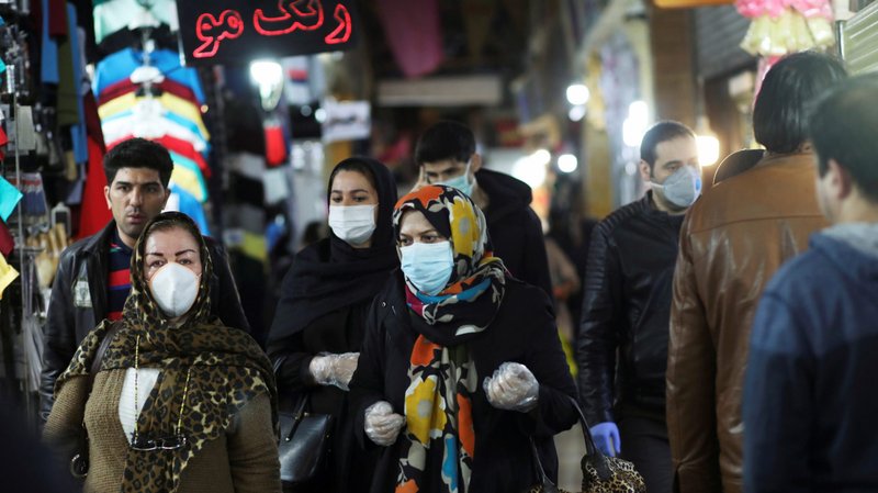 People are seen wearing protective face masks and gloves as they walk in a market in Tehran, Iran, March 18, 2020, during the coronavirus pandemic. (CNS photo/Ali Khara, West Asia News Agency via Reuters)