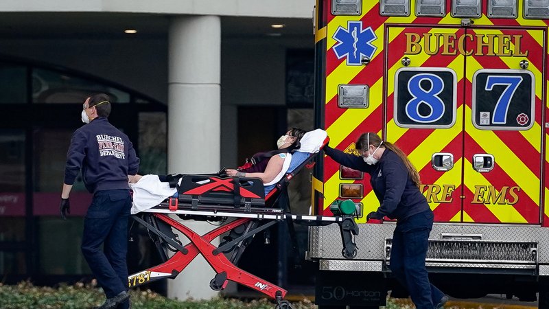 Emergency medical technicians in Louisville, Ky., transport a possible coronavirus patient March 24, 2020, into the emergency department of Norton Women's and Children's Hospital. Amid pandemic, ethicists and lawyers see dangers in rationing of scarce health resources. (CNS photo/Bryan Woolston, Reuters)