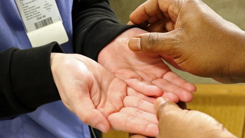 A personal care assistant has her hands anointed May 7, 2018, by Father Corneille Boyeye, chaplain at St. Catherine of Siena Medical Center in Smithtown, N.Y., during the hospital's National Nurses Week observance. Amid the coronavirus pandemic, Catholics nurses are increasingly filling the spiritual void for patients in their care as hospitals restrict visits from pastoral ministers. (CNS photo/Gregory A. Shemitz)