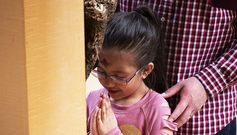 A young girl venerates the cross at the Cathedral of Our Lady of the Angels during Ash Wednesday Mass Feb 26. (Victor Alemán/Angelus News)