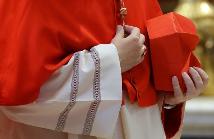 A cardinal holds a red three-cornered biretta hat before a consistory inside the St. Peter's Basilica at the Vatican, Saturday, Nov. 19, 2016. (AP Photo/Gregorio Borgia.)