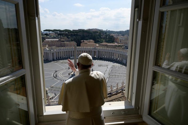 Standing in the window of the Apostolic Palace overlooking an empty St. Peter’s Square, Pope Francis blesses the city of Rome March 15, still under lockdown to pre-vent the spread of the coronavirus. (Vatican Media via Reuters)