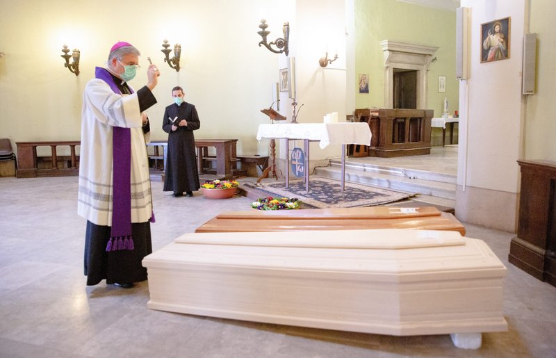 Bishop Pierantonio Tremolada of Brescia, Italy, blesses coffins of COVID-19 victims in the cemetery chapel in Brescia March 24, 2020. (CNS photo/Francesca Volpi, KNA)