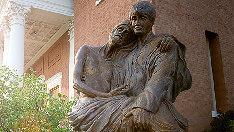 A statue of St. Aloysius Gonzaga carrying a plague victim in his arms is seen on the campus of Gonzaga University in Spokane, Wash., in this undated photo. Born in 1568 to an aristocratic family in Italy, St. Aloysius was accepted into the novitiate of the Society of Jesus in Rome in 1585 and died in 1591 while caring for the sick and dying of the plague days before his 23rd birthday. He was canonized by Pope Benedict XIII in 1726. (CNS photo/courtesy Gonzaga University)