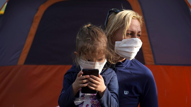 A mother and daughter wearing protective masks who are seeking asylum in the U.S. are seen at a migrant camp in Matamoros, Mexico, April 1, 2020, during the COVID-19 pandemic. (CNS photo/Go Nakamura, Reuters)