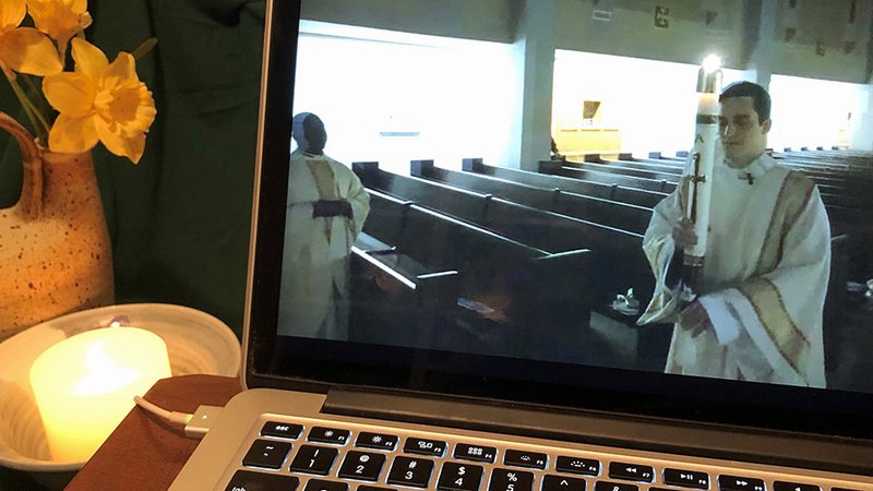 Deacon Peter McShurley of Arlington, Va., is livestreamed as he carries the paschal candle during the Easter Vigil Mass at the Cathedral of St. Thomas More in Arlington April 11, 2020. (CNS photo/Leslie Miller, Catholic Herald)