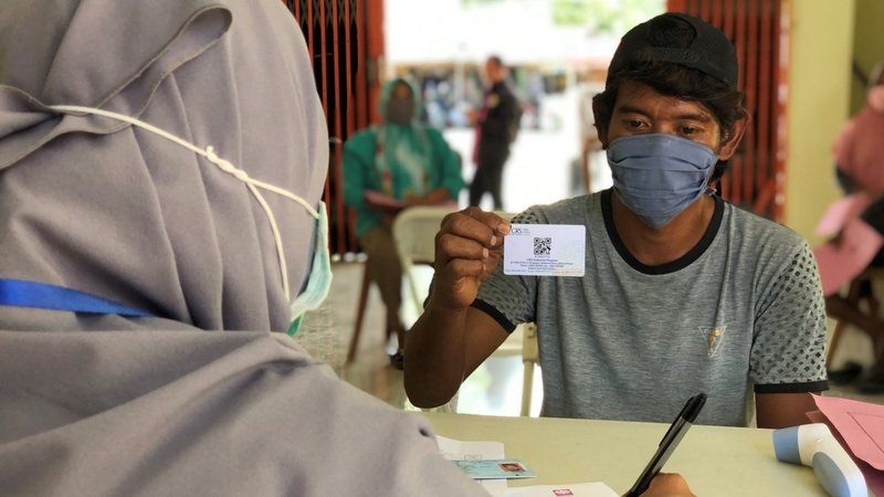 Catholic Relief Services' money distribution in Palu, Indonesia, to families needing cash to retrofit houses damaged in a 2018 tsunami continues, despite the COVID-19 pandemic. (CNS photo/Prillimala Angelisca, courtesy CRS)