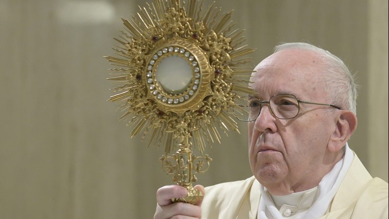 Pope Francis raises the monstrance during eucharistic adoration at the end of Mass in the chapel of his Vatican residence, the Domus Sanctae Marthae, April 22, 2020. (CNS photo/Vatican Media)